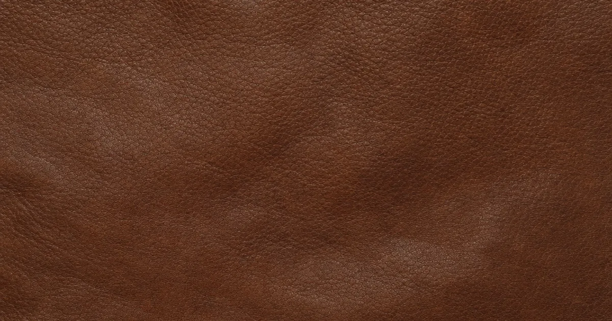 Photorealistic 3D render of rich brown pebbled leather tiled seamlessly across a large surface with soft creases and a gentle uneven sheen under warm studio light